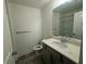 Features include a single sink vanity, gray tiling, and a toilet with an enclosed shower at 7695 Baron Rd, Fairburn, GA 30213