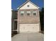 Two-story brick home with a three-car garage and a modern design at 7695 Baron Rd, Fairburn, GA 30213
