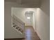 Hallway with stairs and an archway that leads to the front door at 7695 Baron Rd, Fairburn, GA 30213