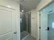 All-white bathroom showcases a glass-enclosed shower with sleek fixtures and gray tiling at 7695 Baron Rd, Fairburn, GA 30213