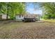 Back exterior shows a house with a wooden deck, a patio, and mature trees at 10149 Puckett Sw St, Covington, GA 30014