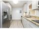 Bright kitchen with stainless steel appliances, granite countertops and gray cabinetry at 10149 Puckett Sw St, Covington, GA 30014