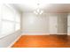 Bright living room features gleaming hardwood floors, a modern chandelier, and ample natural light at 10149 Puckett Sw St, Covington, GA 30014