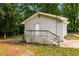 Rear view shows a painted brick structure, small wooden deck, and a small patio at 10149 Puckett Sw St, Covington, GA 30014