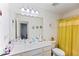 Well-lit bathroom features a spacious vanity, a large mirror, and a bright yellow shower curtain at 124 Saginaw Ct, Locust Grove, GA 30248