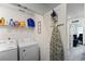 Bright laundry room features white washer and dryer, shelving, and ironing board at 124 Saginaw Ct, Locust Grove, GA 30248