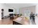 Open-concept living room with hardwood floors, ceiling fan, large TV, dining table and access to the backyard at 124 Saginaw Ct, Locust Grove, GA 30248