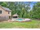 Beautiful backyard showcasing a private pool, covered patio, and serene wooded surroundings at 561 Holland Rd, Dallas, GA 30157