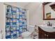 Cozy bathroom featuring a quirky shower curtain, single sink vanity and an updated toilet at 561 Holland Rd, Dallas, GA 30157