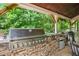 Built-in stone grill with stainless steel appliances and mini fridge at 561 Holland Rd, Dallas, GA 30157