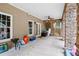 Covered patio with stone columns and a ceiling fan, offers an inviting outdoor living space and backyard access at 561 Holland Rd, Dallas, GA 30157
