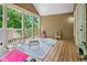 This screened porch includes wood flooring, neutral-colored siding, and metal patio furniture at 561 Holland Rd, Dallas, GA 30157