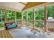 Relaxing screened porch featuring wood flooring, comfortable seating, and picturesque views of the lush backyard at 561 Holland Rd, Dallas, GA 30157