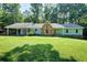 Charming single-story home with stone accents and a lush green lawn, nestled among mature trees at 2612 Spring St, Dacula, GA 30019