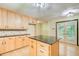 Light filled eat-in kitchen features light wood cabinets, center island and glass panel door to backyard at 2612 Spring St, Dacula, GA 30019