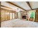 Cozy living room features a stone fireplace, wood paneling, and exposed beam ceiling at 2612 Spring St, Dacula, GA 30019