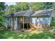 Back exterior view featuring a screened porch and access to the basement, perfect for outdoor living at 2612 Spring St, Dacula, GA 30019