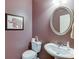 Elegant powder room featuring an oval mirror, decorative art, and a pedestal sink at 3393 Sardis Bend Dr, Buford, GA 30519