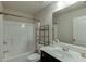 Bathroom featuring a tub with a shower, dark cabinets, a mirror, and a sink at 3393 Sardis Bend Dr, Buford, GA 30519