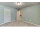A bright bedroom featuring neutral carpeting, a light and door leading to the stairway at 3393 Sardis Bend Dr, Buford, GA 30519