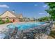 A lovely community pool with lounge chairs, umbrellas, and a building with brick accents and tables at 3393 Sardis Bend Dr, Buford, GA 30519