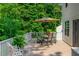 Outdoor back deck featuring a dining table set, umbrella, and lush green foliage at 350 Birch Rill Dr, Alpharetta, GA 30022
