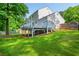Backyard view of the deck with dining table, mature trees and lush green grass at 350 Birch Rill Dr, Alpharetta, GA 30022