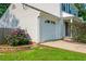 Attached one-car garage and partially bricked flower garden with purple flowers in a charming suburban home at 350 Birch Rill Dr, Alpharetta, GA 30022