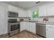 Functional kitchen featuring white cabinets, stainless steel appliances, and durable flooring at 350 Birch Rill Dr, Alpharetta, GA 30022