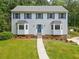 Charming two-story home with light blue siding, blue shutters, bay windows, and a well-manicured front lawn at 4197 Chadds Xing, Marietta, GA 30062