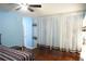 Cozy bedroom with hardwood floors, a ceiling fan, and decorative curtains at 852 Glynn Oaks Dr, Clarkston, GA 30021