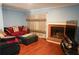 Cozy living room featuring a brick fireplace, hardwood floors, and large window at 852 Glynn Oaks Dr, Clarkston, GA 30021