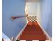 Stairway with red painted steps and a contrasting black-and-white checkered landing, leading to the upper level at 852 Glynn Oaks Dr, Clarkston, GA 30021
