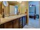 Bathroom features a double vanity with dark wood cabinets and a view into the bedroom at 110 Baltusrol Way, Covington, GA 30014