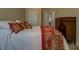Bedroom with a colorful duvet, dark wood dresser, and a view into the hallway at 110 Baltusrol Way, Covington, GA 30014