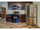 Kitchen featuring stainless steel appliances, wood floors, and dark cabinets at 110 Baltusrol Way, Covington, GA 30014