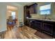 Well-lit kitchen with wood floors, stainless steel sink and dark wood cabinets at 110 Baltusrol Way, Covington, GA 30014