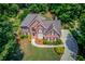 Aerial view of brick home with well maintained landscaping, gray shingle roof, and long paved driveway at 1721 Crowes Lake Ct, Lawrenceville, GA 30043