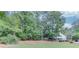 Lush backyard with mature trees, manicured lawn, and a glimpse of the home's exterior at 1721 Crowes Lake Ct, Lawrenceville, GA 30043