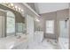 Bright bathroom with double sinks, a window, and a glass-enclosed shower at 1721 Crowes Lake Ct, Lawrenceville, GA 30043