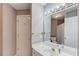 Well-lit bathroom features a large mirror, white cabinets, sink and a door at 1721 Crowes Lake Ct, Lawrenceville, GA 30043