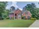 Charming two-story brick home featuring a manicured lawn and mature trees on a beautiful lot at 1721 Crowes Lake Ct, Lawrenceville, GA 30043