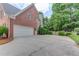 Spacious three car garage features a long driveway and mature greenery at 1721 Crowes Lake Ct, Lawrenceville, GA 30043