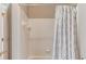 Clean white shower with tiled walls and a stylish gray patterned shower curtain at 1721 Crowes Lake Ct, Lawrenceville, GA 30043