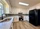Well-lit kitchen featuring white cabinets, stainless steel appliances, grey backsplash, and modern black hardware at 2535 Impala Dr, Cumming, GA 30041