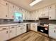 Modern renovated kitchen featuring white cabinets, stainless appliances, gray backsplash, and black hardware at 2535 Impala Dr, Cumming, GA 30041