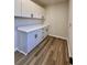 Laundry area with white cabinets, counter space, new flooring, and black hardware at 2535 Impala Dr, Cumming, GA 30041
