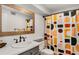 Modern bathroom with colorful shower curtain, a vanity, and a decorative mirror at 2955 Rhodenhaven Nw Dr, Atlanta, GA 30327