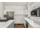 Corner view of the kitchen featuring a stainless refrigerator, white cabinets, and marble backsplash at 2955 Rhodenhaven Nw Dr, Atlanta, GA 30327