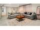 Spacious living room with tile floors, gray sofas, a wood coffee table, and sheer curtains at 2955 Rhodenhaven Nw Dr, Atlanta, GA 30327